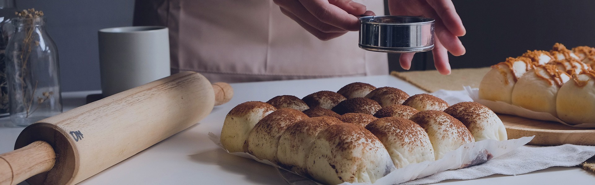 sprinkling cinnamon on buns